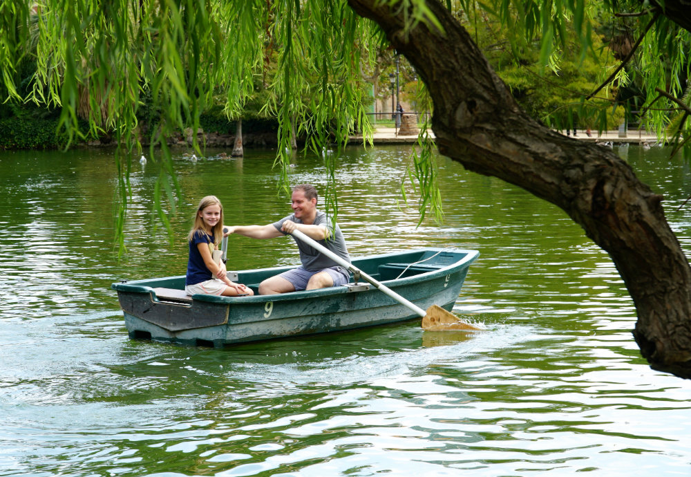 Father-daughter row boat ride at the lake in Ciutadella park in Barcelona.