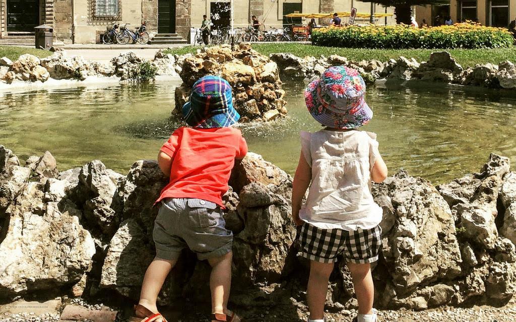 Kids looking at a fountain in Lucca on a summer family vacation with Katy from Untold Morsels.