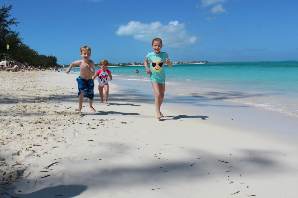Kids running on the beach at Turks and Caicos.